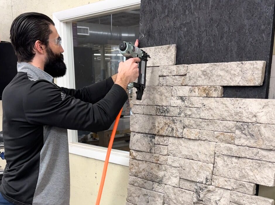 Daniel Fritz, VP for Evolve Stone, installs Evolve Stone mortarless, nailable stone veneer on a wall panel.